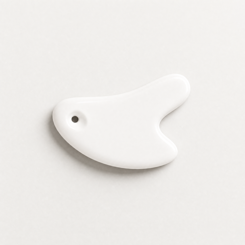 Tessora Ceramic Gua Sha Tool in white on a soft off-white background