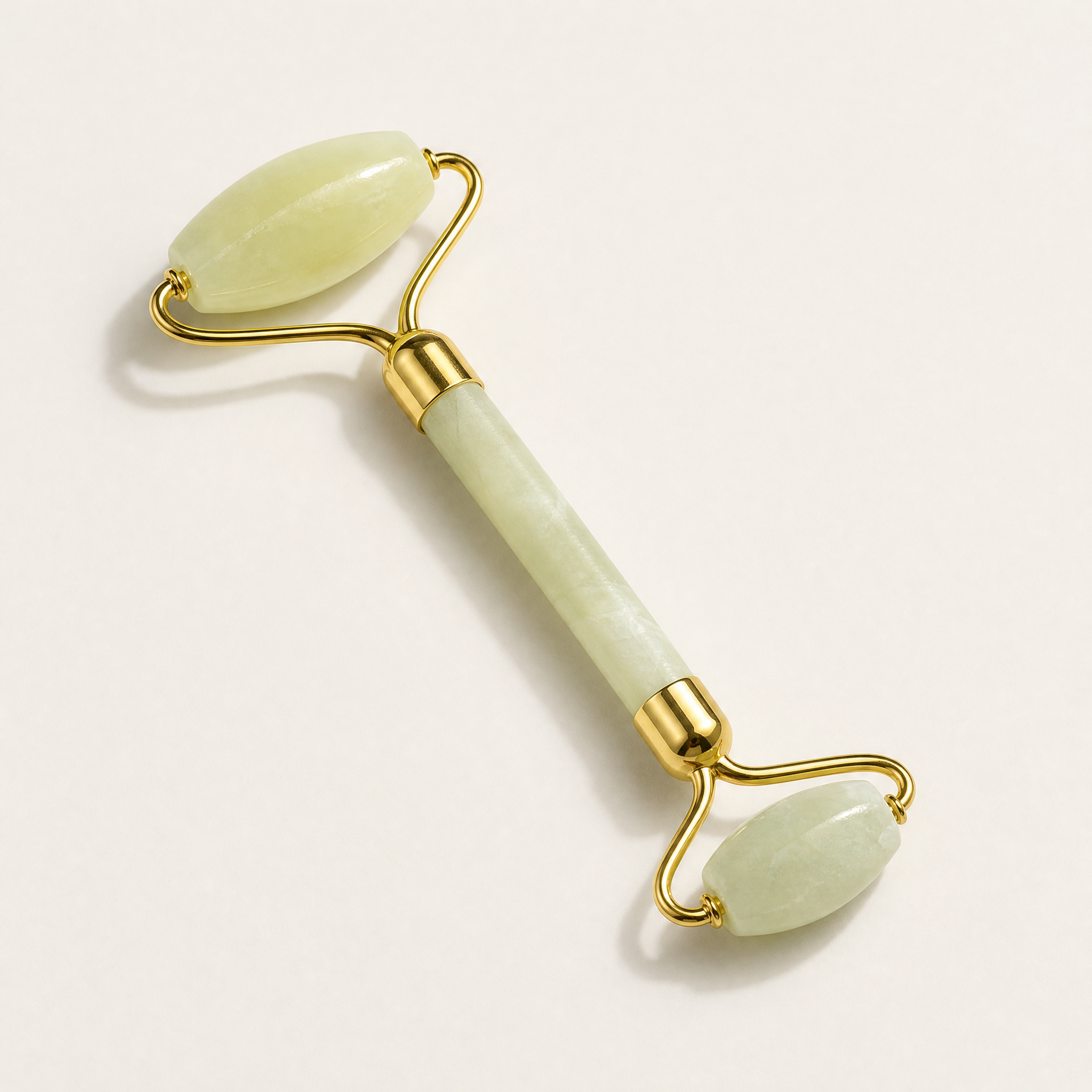 Tessora Jade Facial Roller with gold hardware on a soft off-white background
